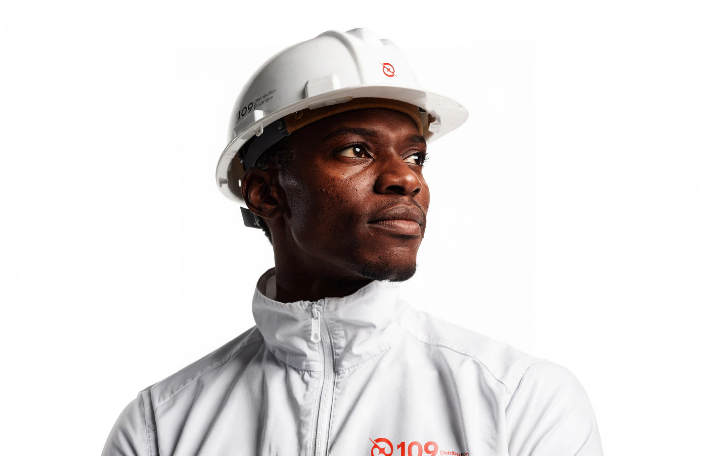 A worker in a white 109 jacket and hard hat