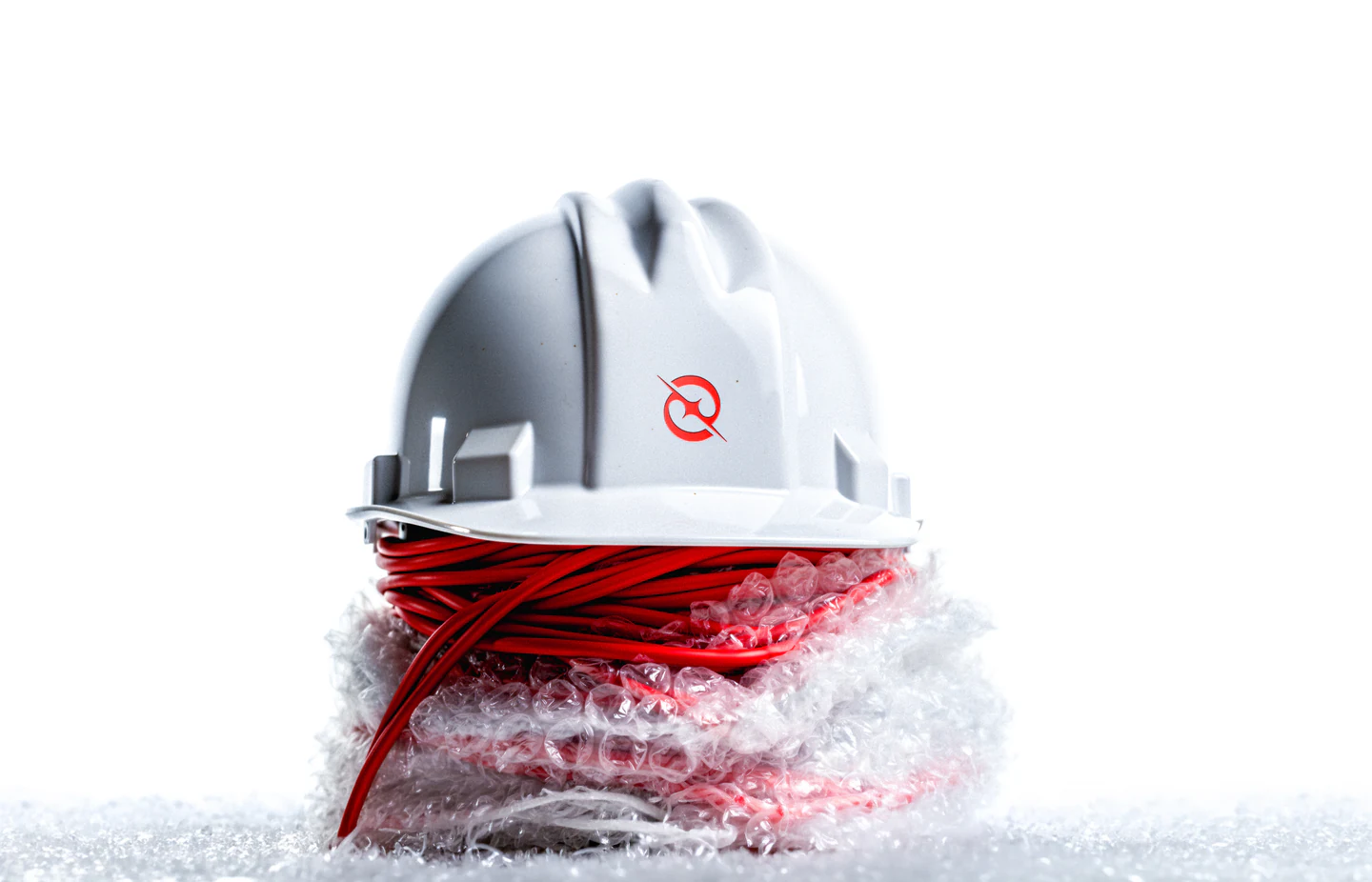 A white hard hat with the logomark on red cable