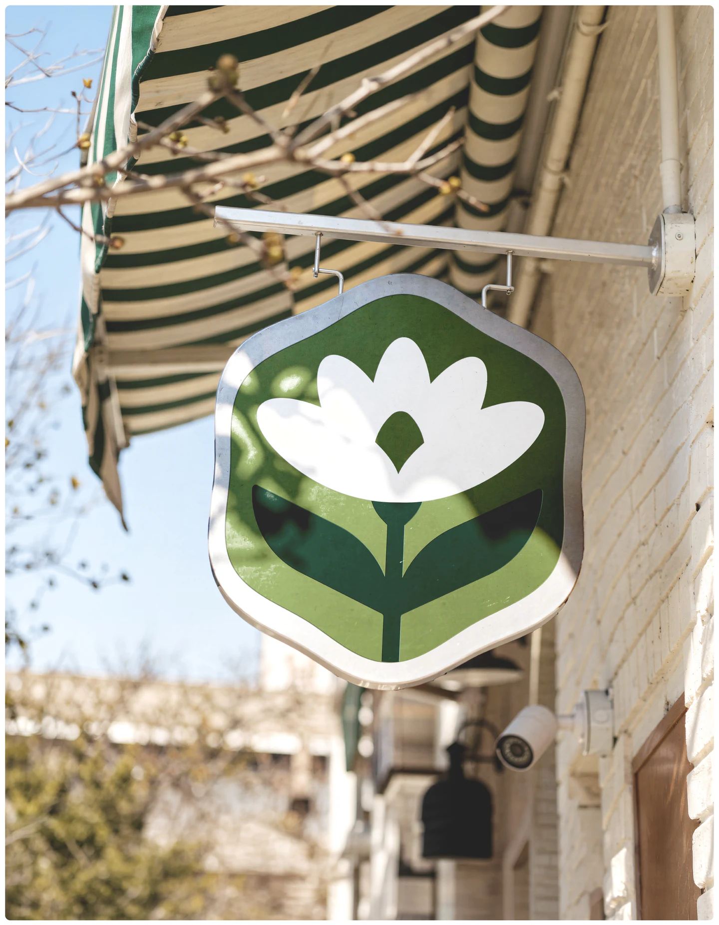 A hexagonal hanging sign under a striped awning