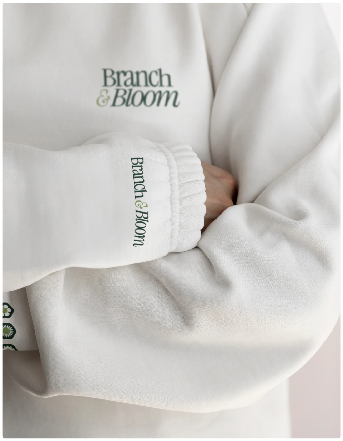 A cream sweater with the wordmark on the sleeve