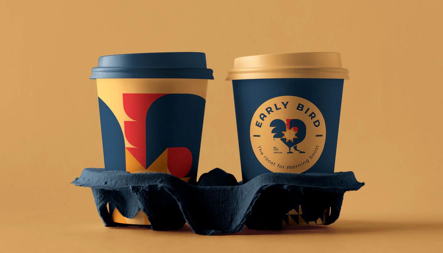 Two Early Bird cups in a carrier on a sand-orange background