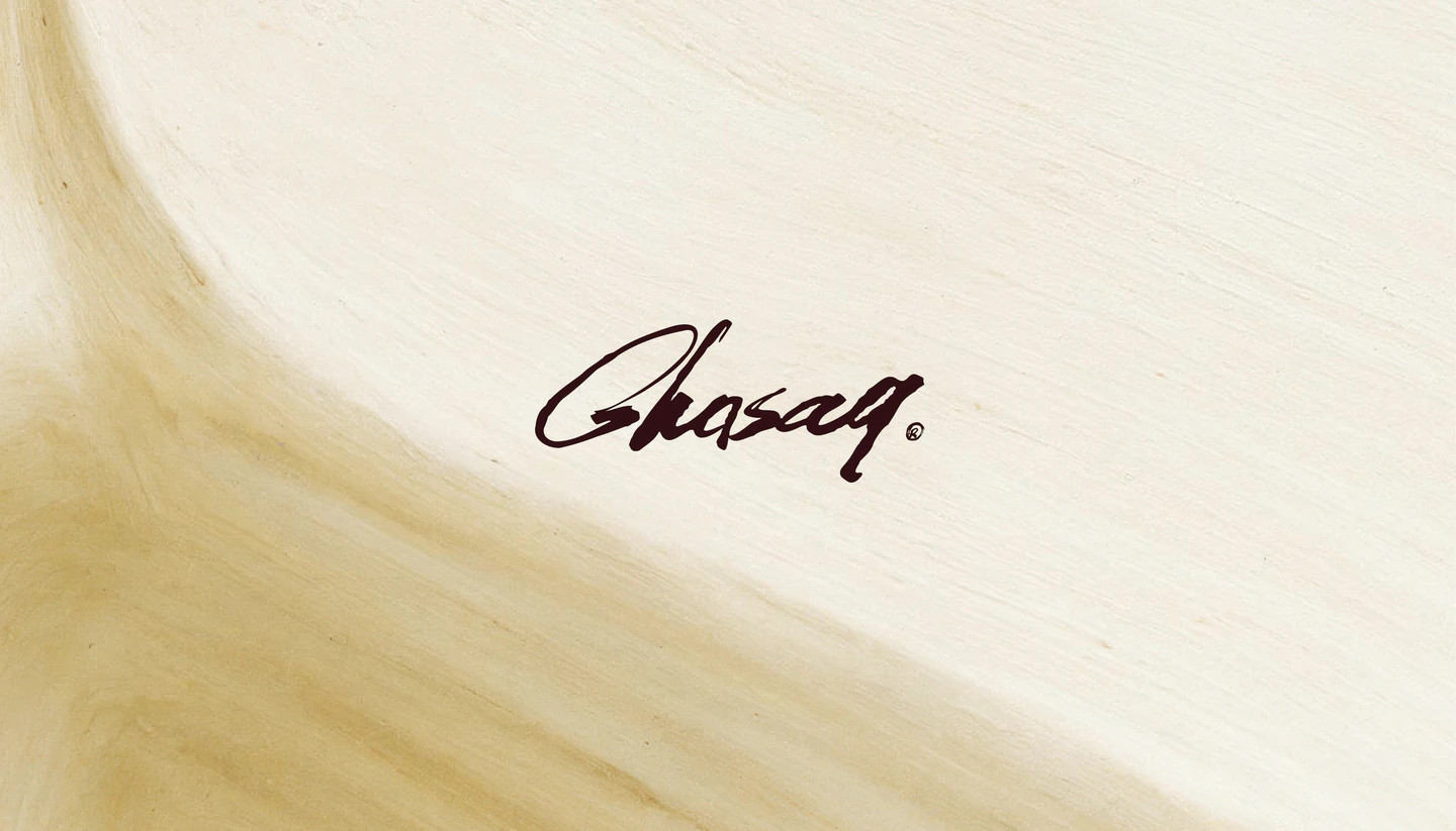 The Ghasaq signature on soft, sand-coloured fabric