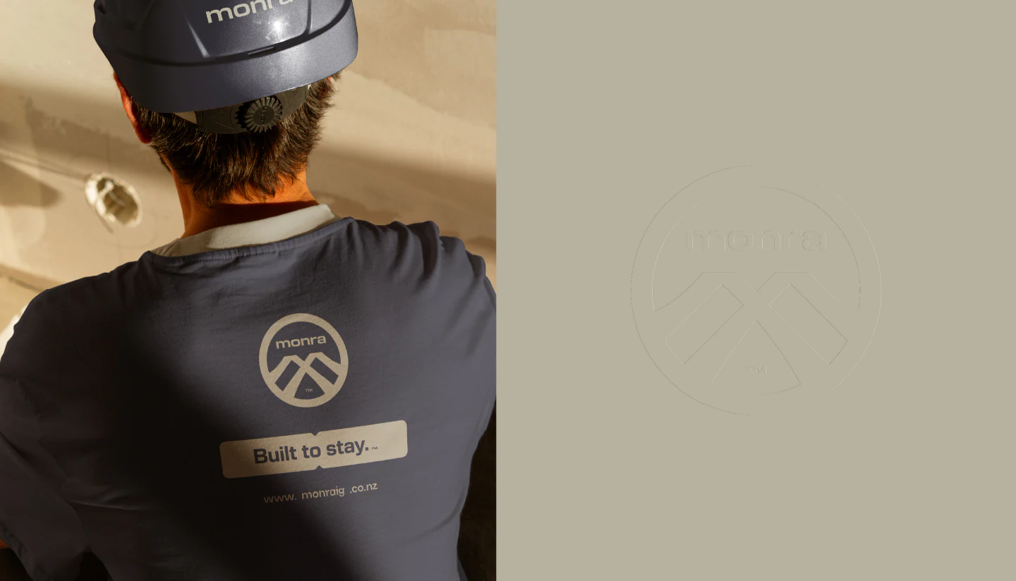 Back of a worker’s tee and helmet with the Monra emblem