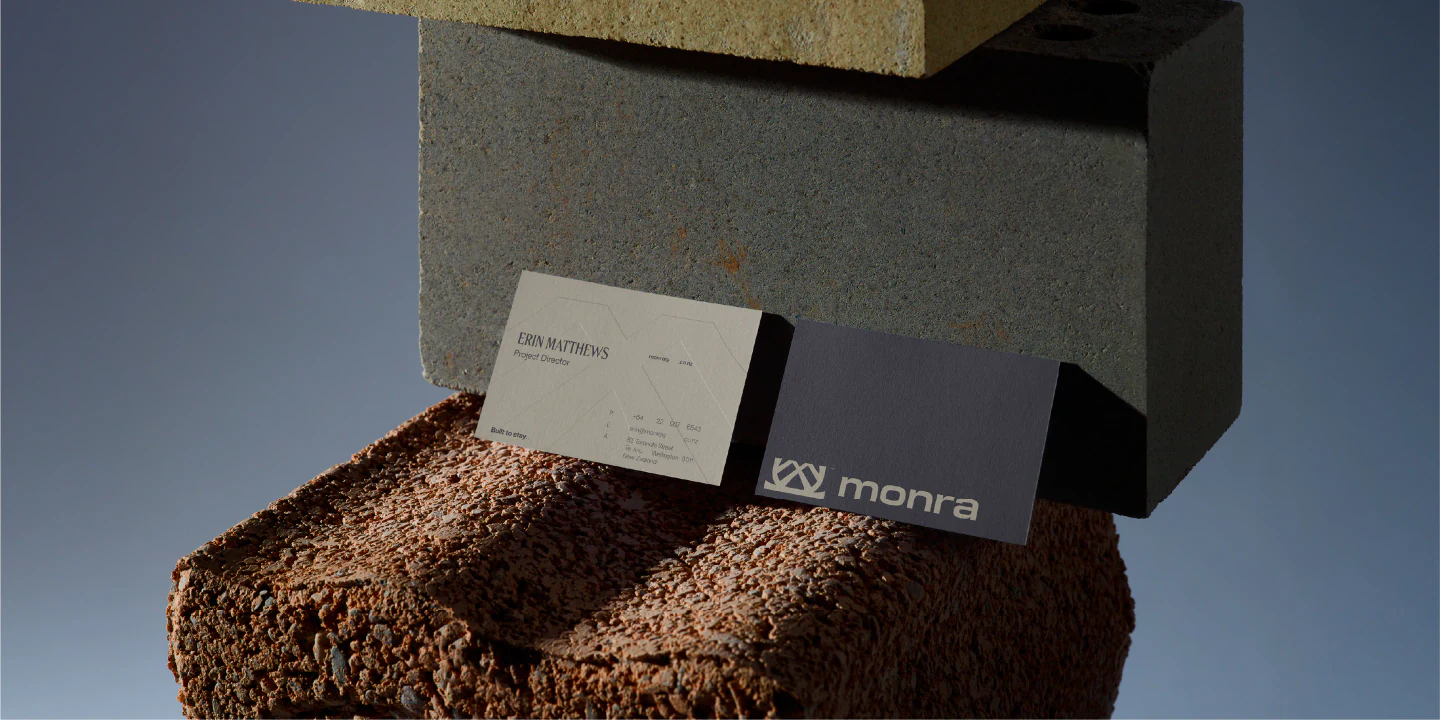 Monra business cards resting on a brick