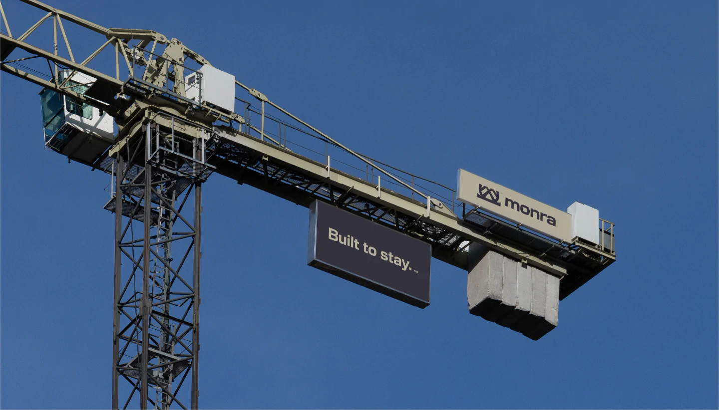 A Built to Stay sign hanging from a tower crane