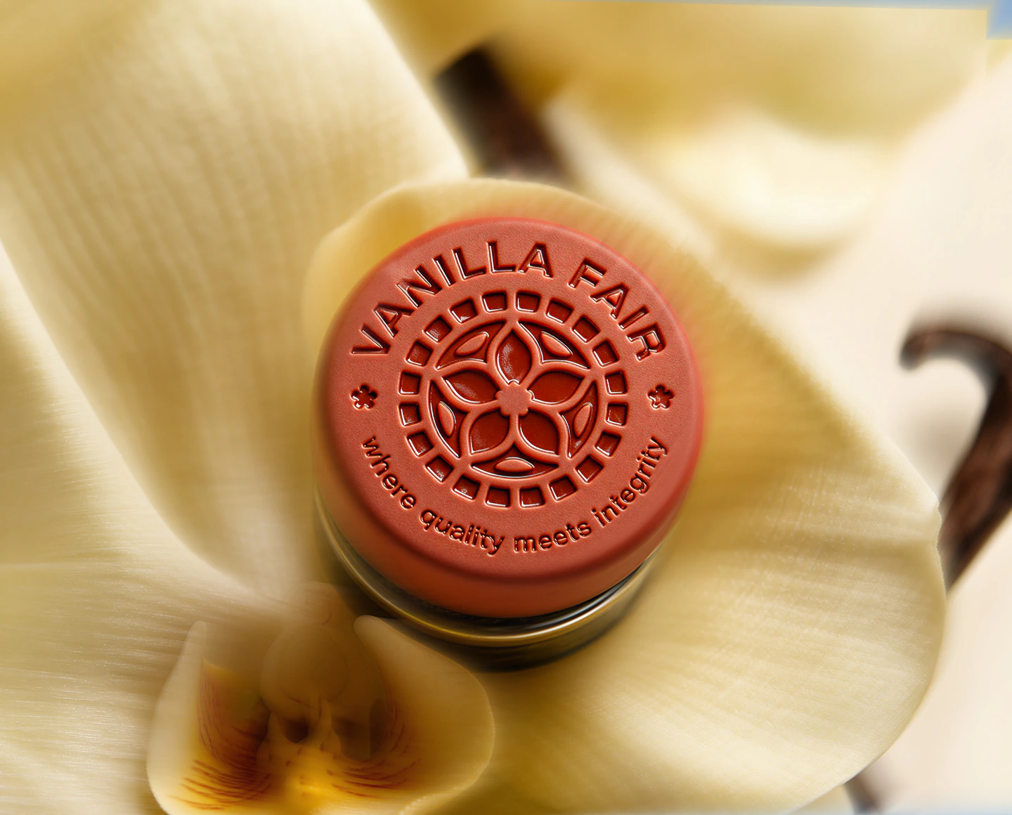 A Vanilla Fair wax seal resting in an open vanilla flower